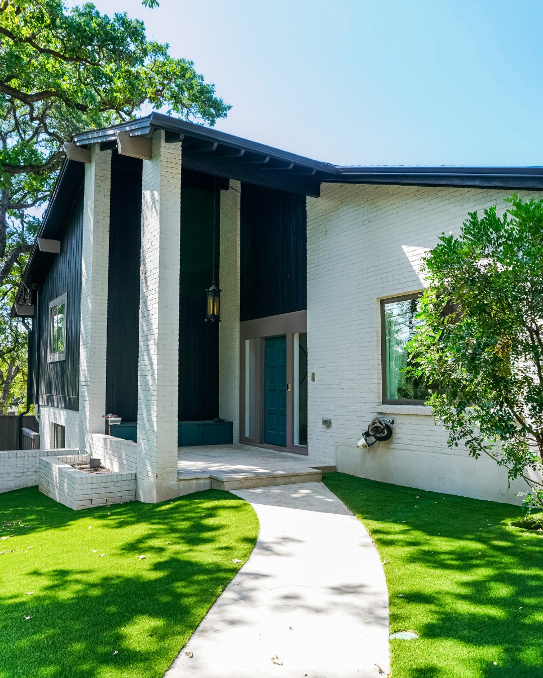 Artificial grass front lawn on both sides of a curved walkway to the front door