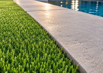 Clean artificial turf edge meeting a concrete pool deck