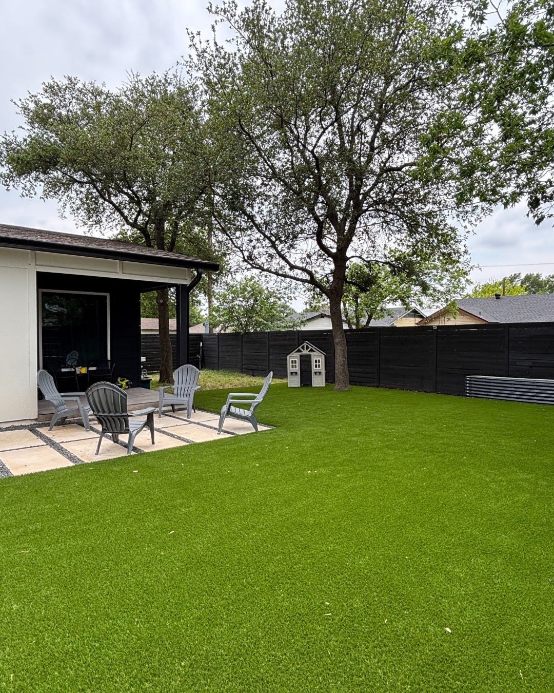 Artificial turf backyard lawn next to a covered patio