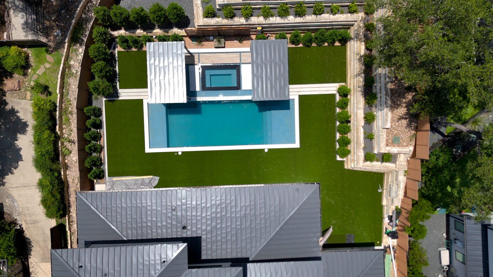 Aerial view of an artificial turf backyard surrounding a pool