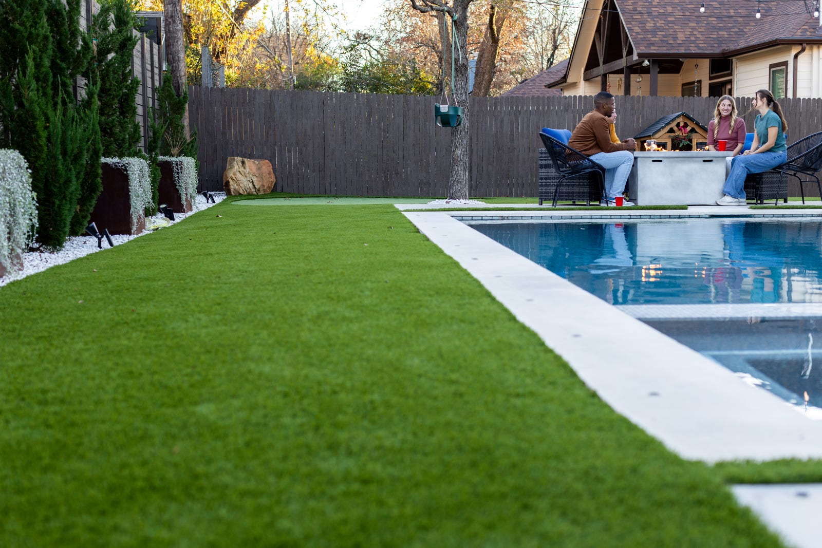 Artificial turf along a pool deck with a backyard putting green